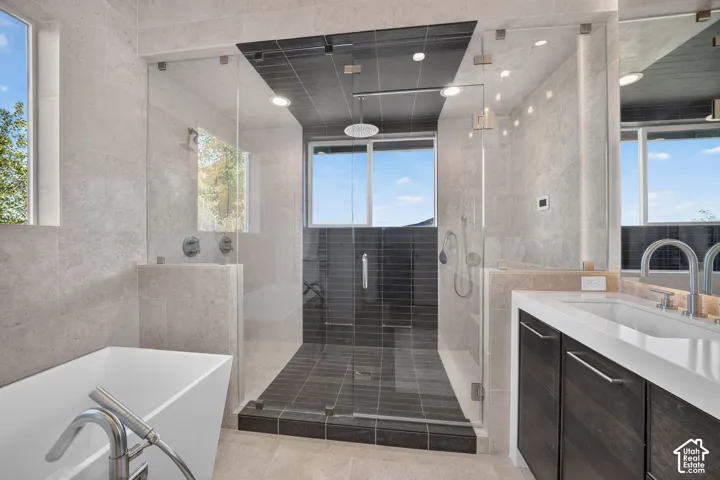 Walk-in shower with dark tile, glass enclosure, and rain shower head