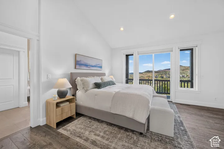 Vaulted ceiling, recessed lighting, expansive glass doors, wood-finish flooring, and direct outdoor access