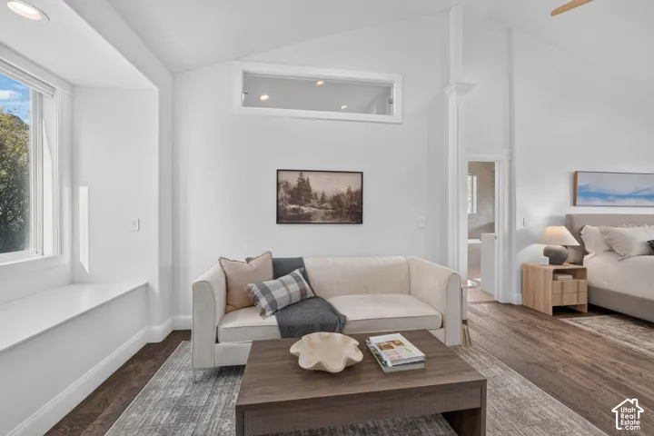 Vaulted ceilings with wood-finish flooring, featuring a large window with a built-in window seat