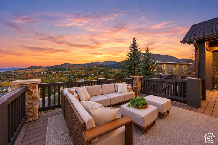 Expansive exterior deck featuring composite decking, wood railings, and stone pillars