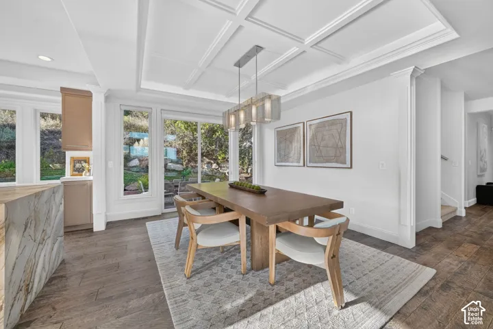 Coffered ceiling, wood-finish flooring, sliding glass doors, built-in cabinetry, and a waterfall-edge island