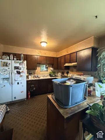 Kitchen featuring wood-finish cabinetry, patterned flooring, and a built-in range hood