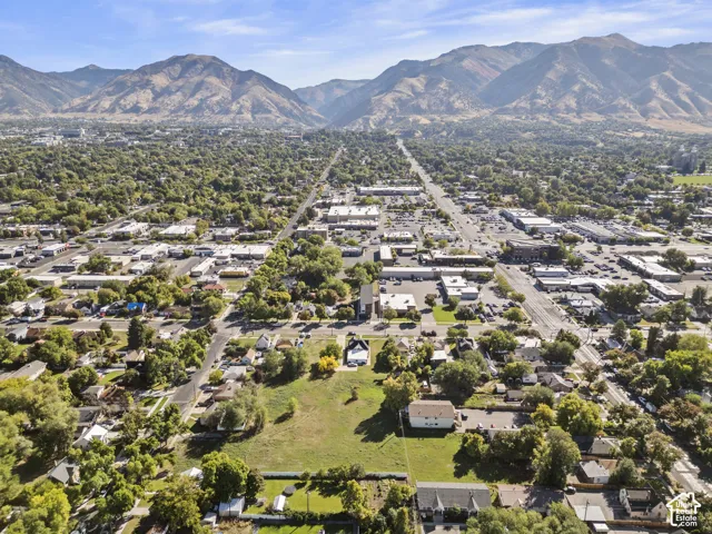 Expansive mountain backdrop with a surrounding urban landscape and green spaces