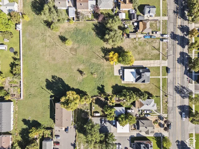 Expansive undeveloped lot with partial fencing, surrounded by established residential properties
