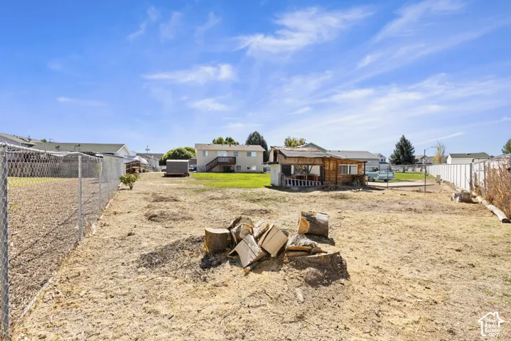 Chain link fence enclosing a spacious yard area with a small detached outbuilding