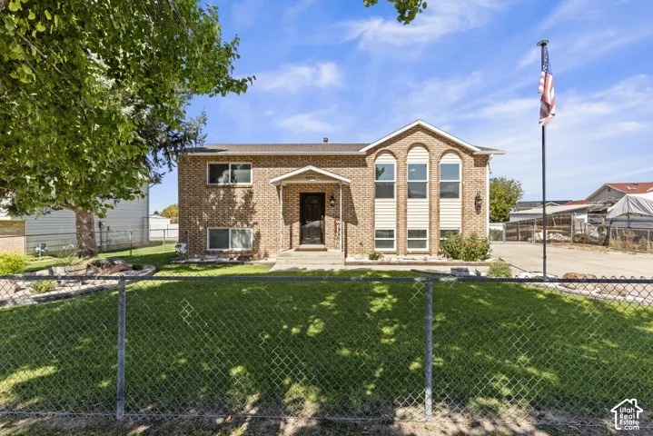 Brick exterior with arched windows, covered front entry, and established landscaping