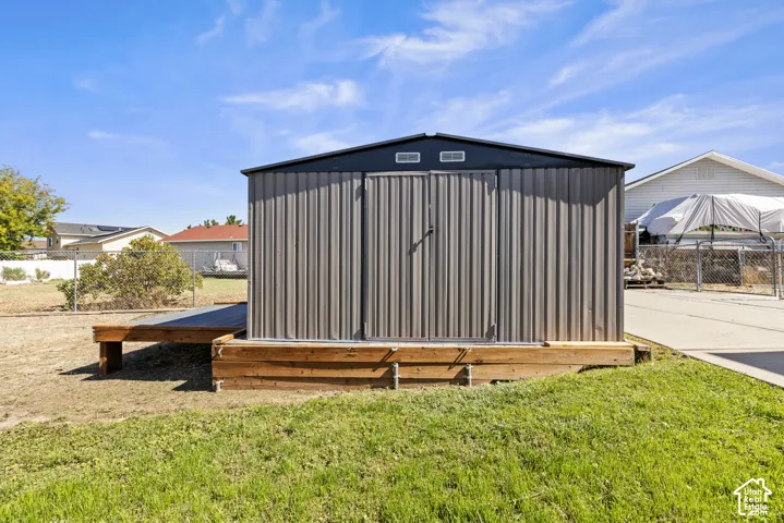 Metal storage shed featuring a dual-door entry and an attached wooden platform