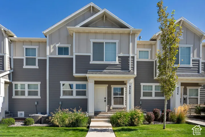 Modern townhome exterior featuring multi-toned siding, white trim, and a prominent gable roofline