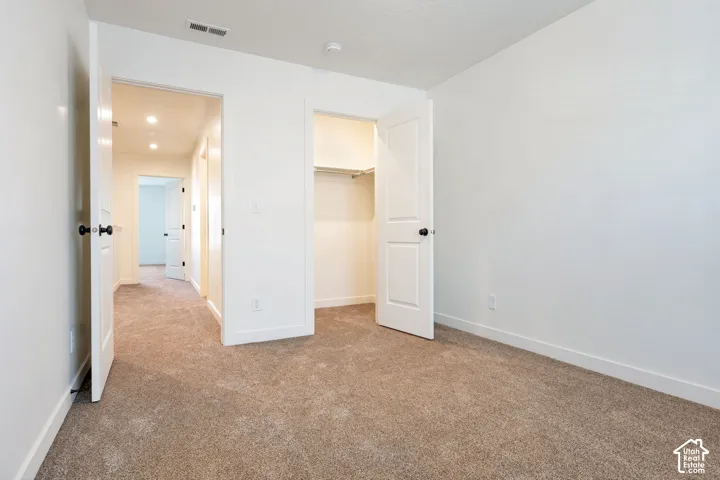 Neutral wall finishes and brown carpeted flooring