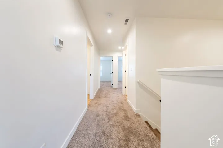 Neutral wall tones, recessed lighting, and soft carpeting