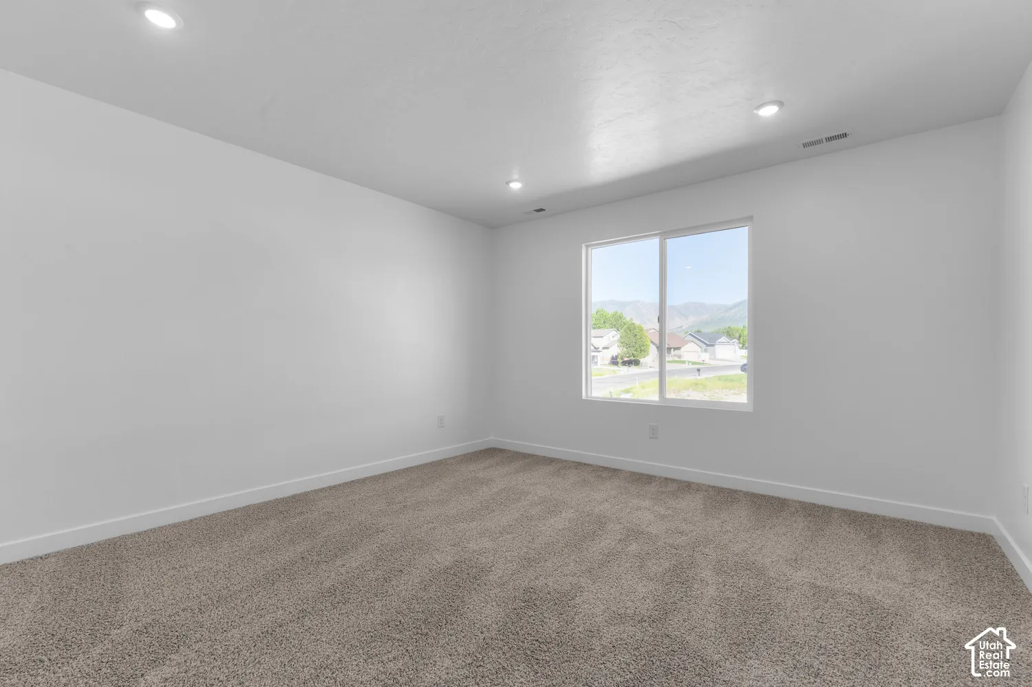 Neutral-toned carpet flooring and white painted walls create a versatile interior