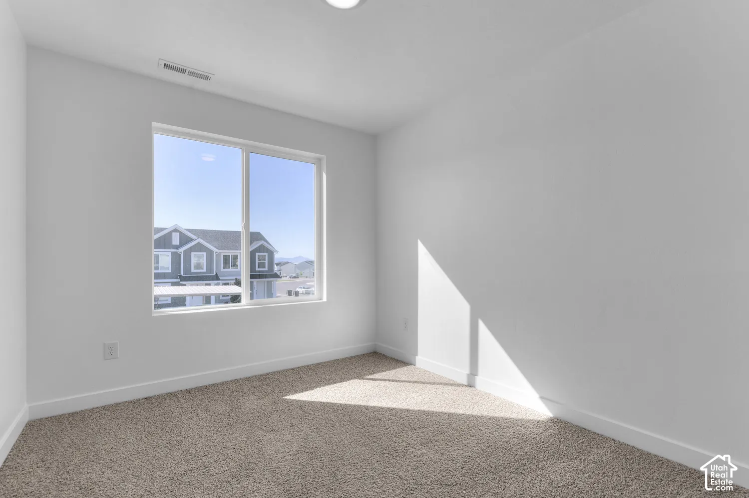 Recessed ceiling lighting, a large window, neutral wall color, and carpeted flooring