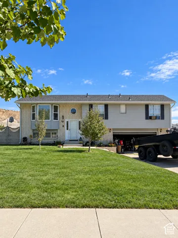 Two-story home with brick and siding exterior, front yard, and concrete driveway