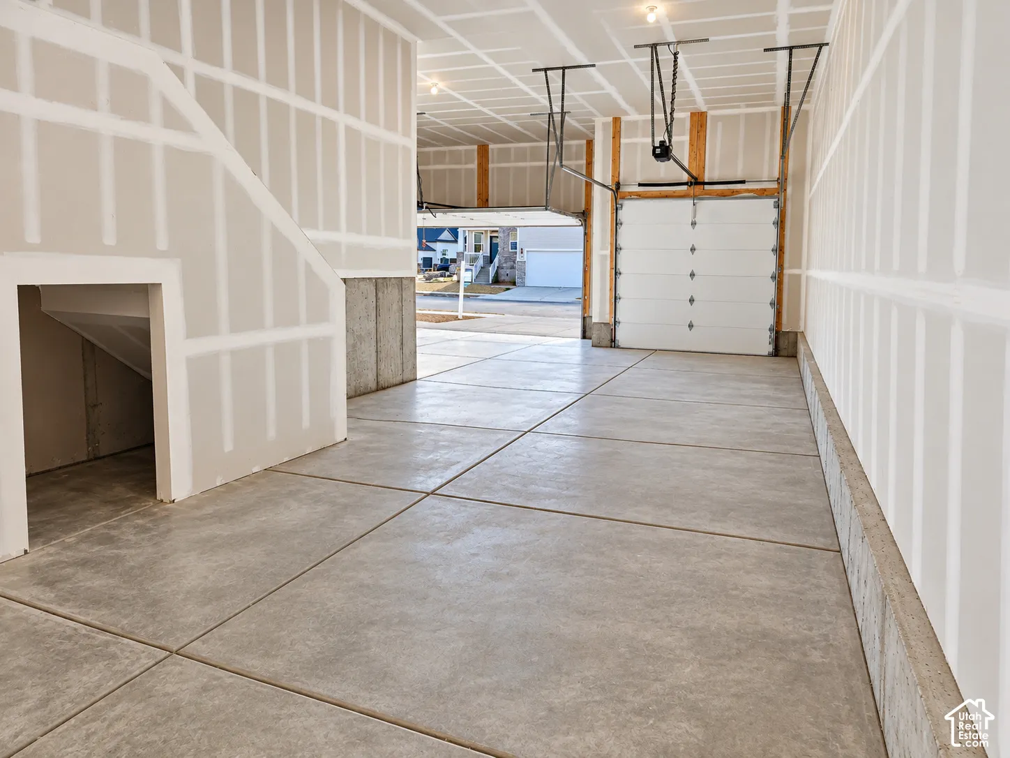Spacious two-car garage with concrete flooring and exposed drywall