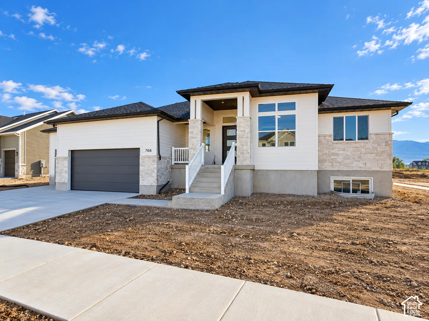 Contemporary exterior with white siding and stone accents