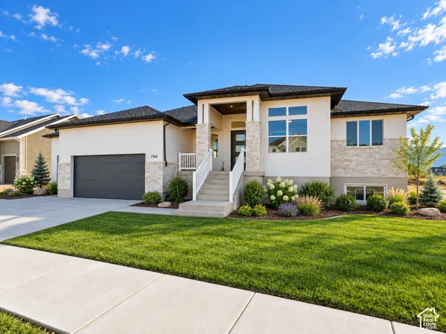 Contemporary exterior with a stone and siding facade, a dark gray garage door, and a concrete driveway