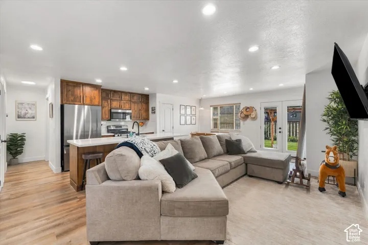 Open-concept living space with wood-finish flooring, recessed lighting, and white walls
