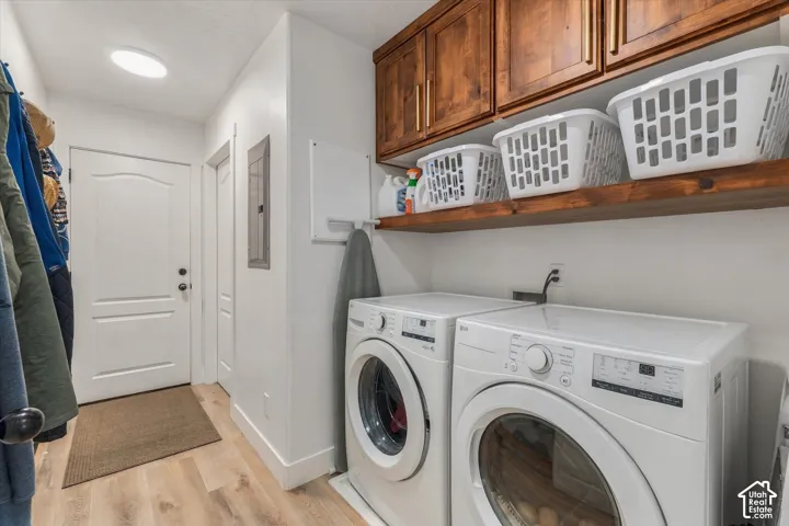 Laundry area with wood-finish flooring, white walls, and a white interior door