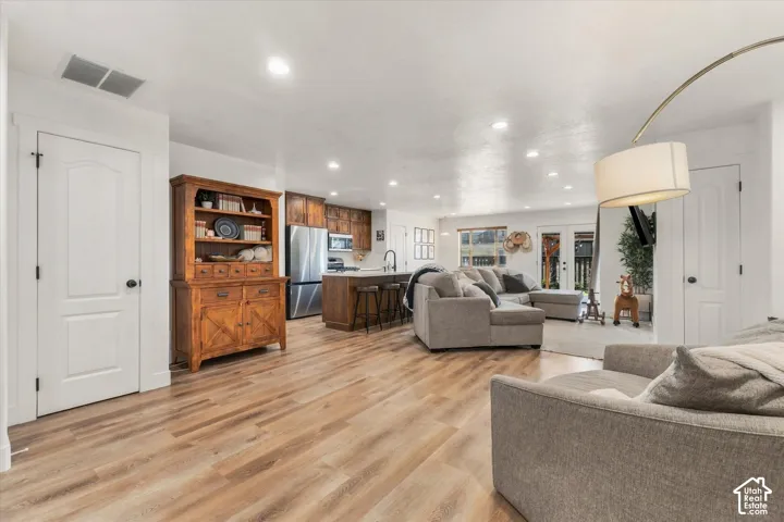 Expansive room featuring wood-finish flooring, recessed lighting, and white trim