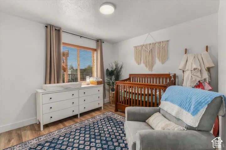 Recessed lighting, wood-finish flooring, and a window with blinds