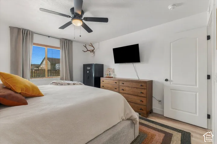Wood-finish flooring, white walls, and a window with blinds