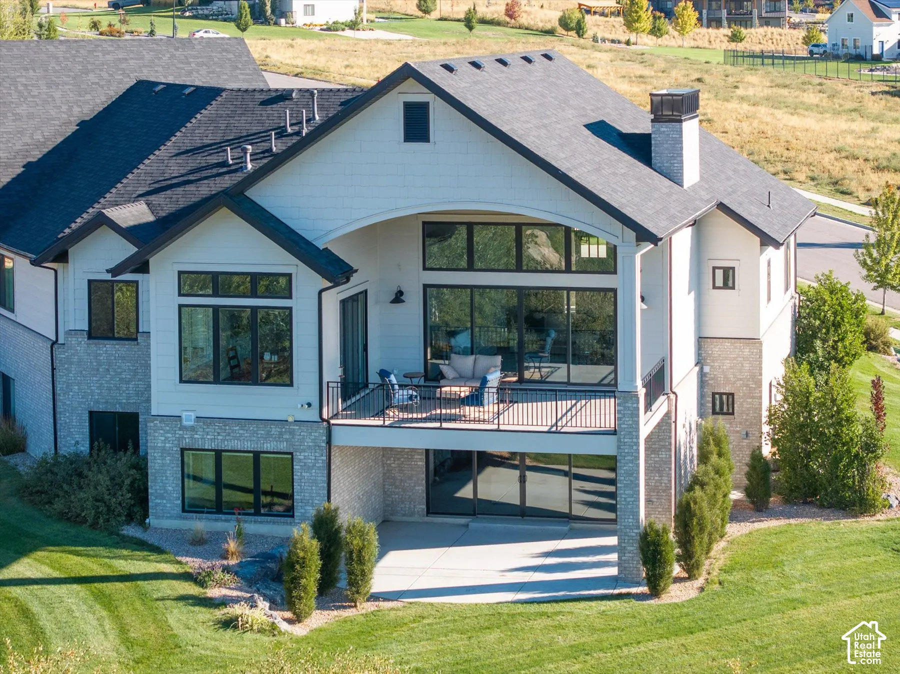 Multi-story exterior with a covered balcony and an additional lower-level patio