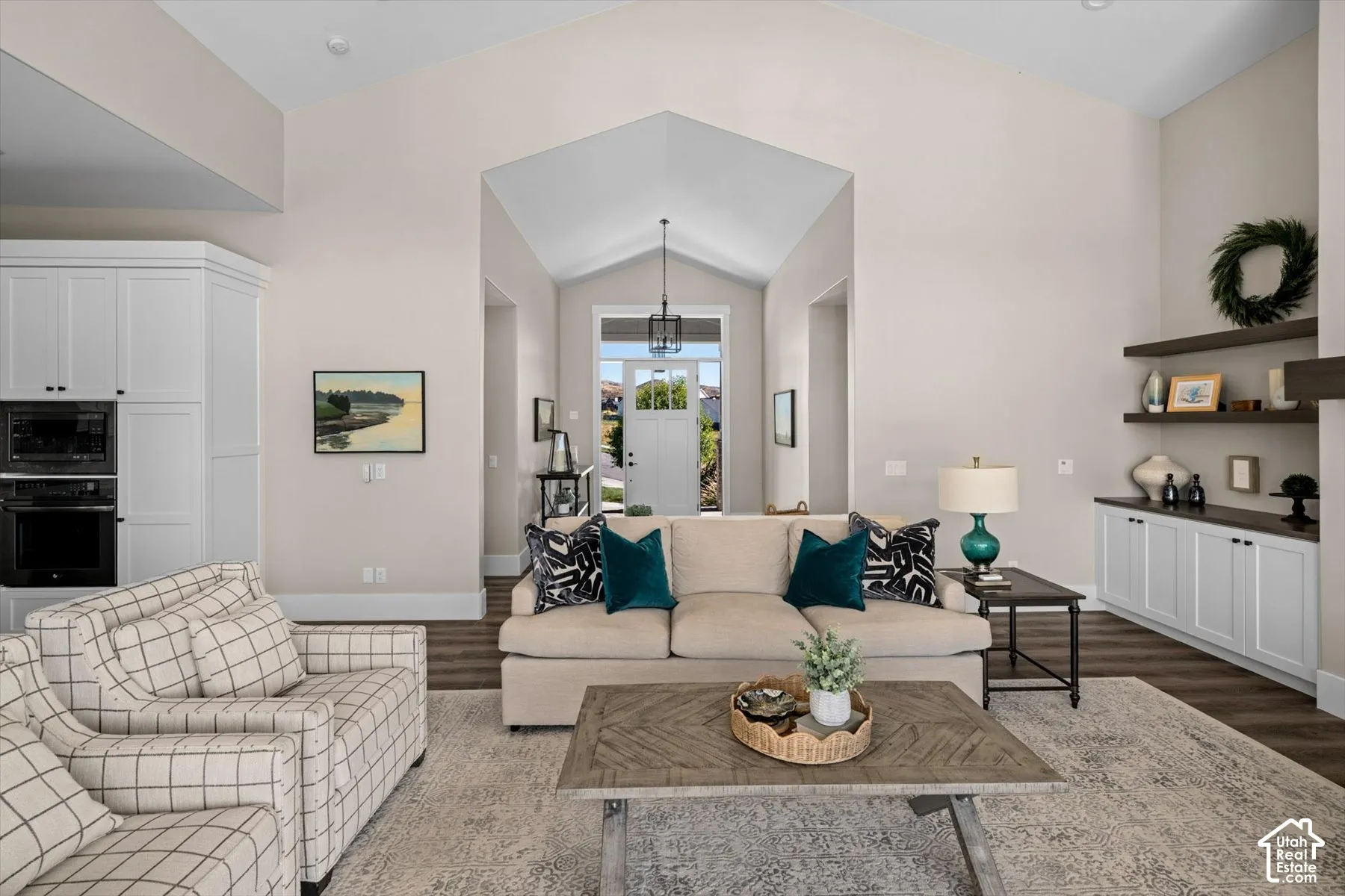 Vaulted ceilings, built-in cabinetry, wood-finish flooring, recessed lighting, and a modern front entry door