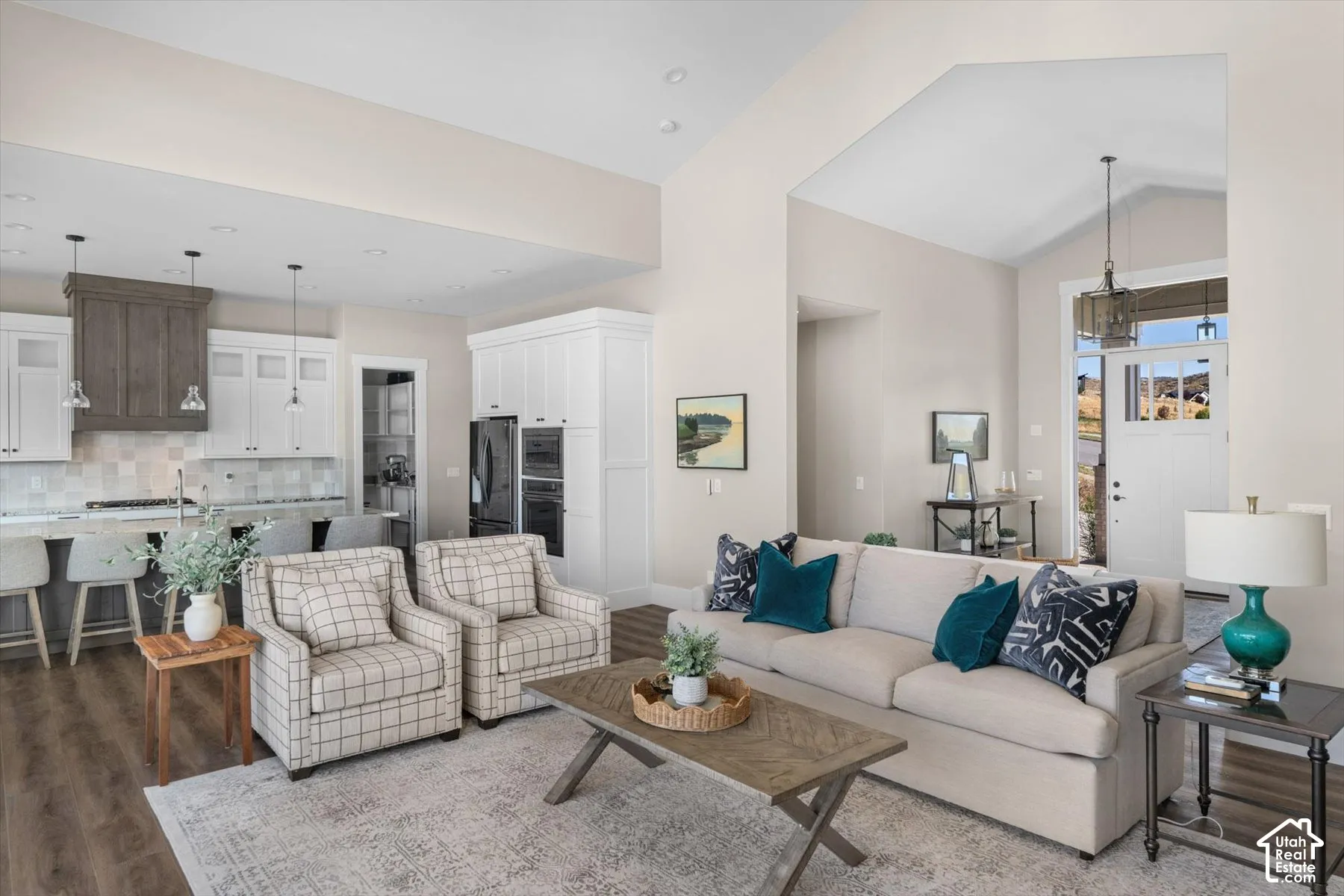 Open-concept living space featuring wood-finish flooring and vaulted ceilings