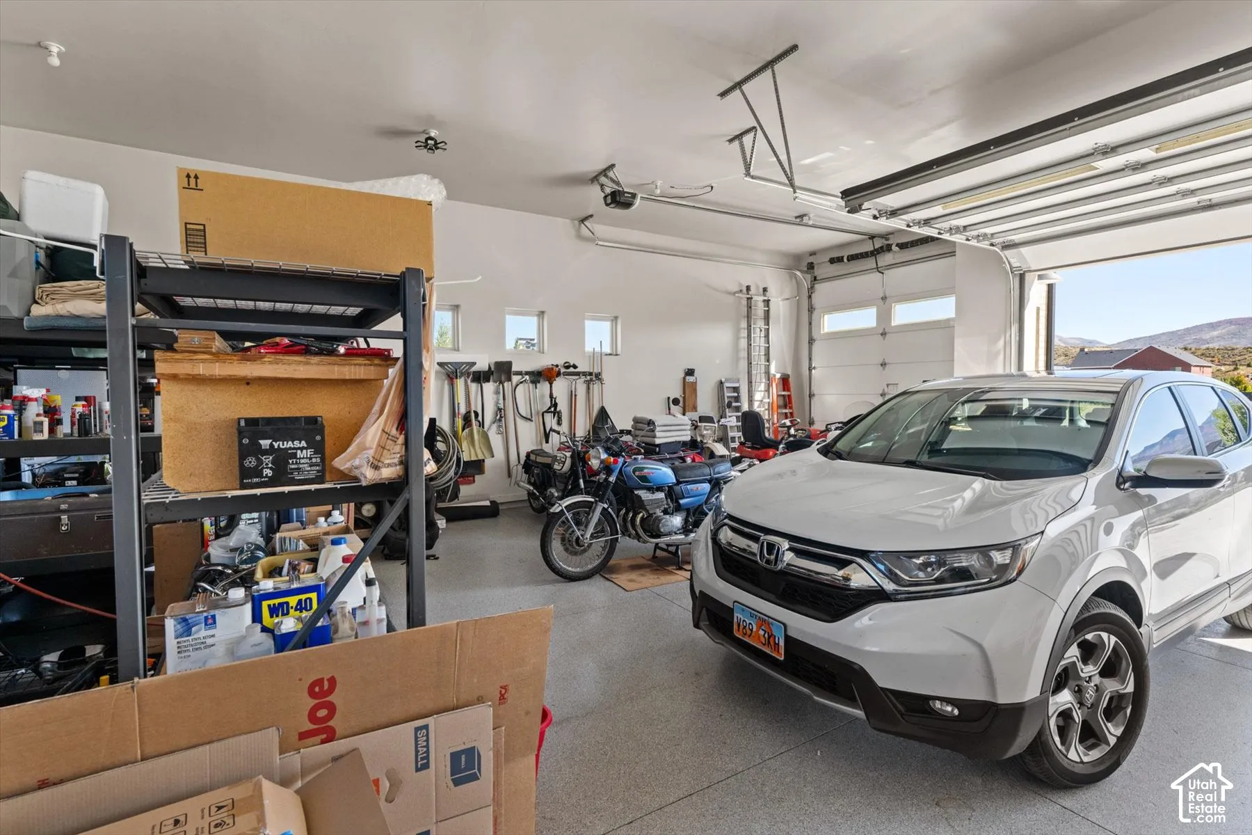 Attached garage with an epoxy-coated floor, multiple windows, and overhead lighting