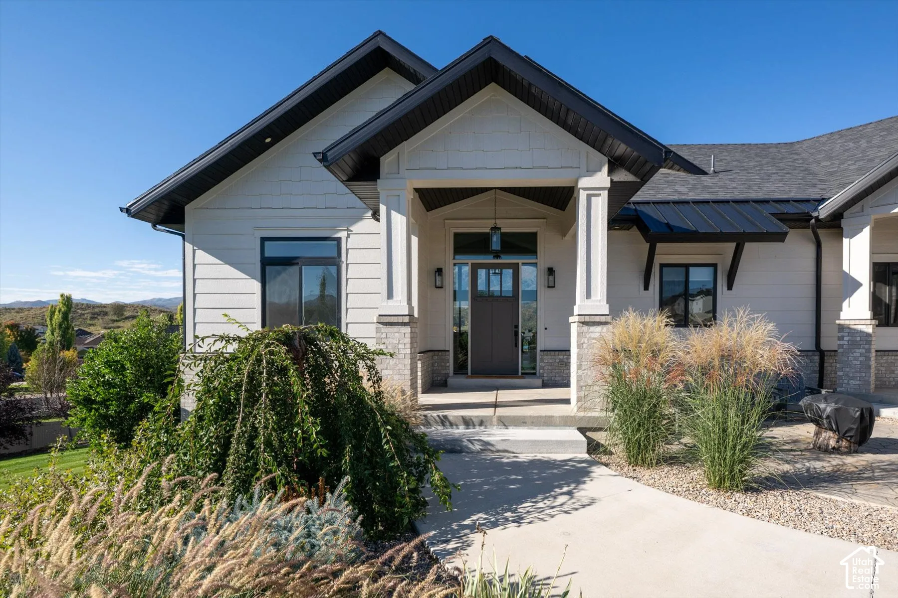 Modern farmhouse exterior with white siding and a gray stone accent