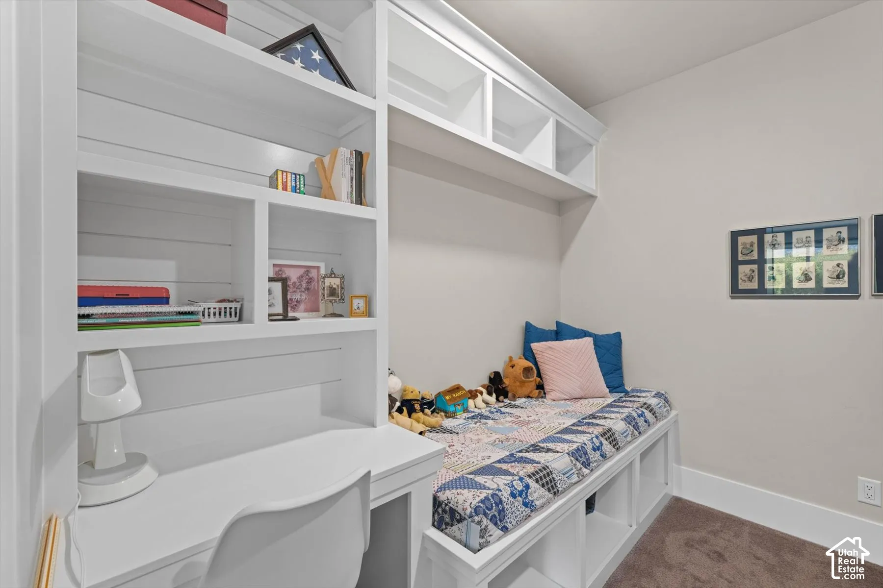 Built-in desk and shelving unit with an integrated daybed, featuring storage cubbies below