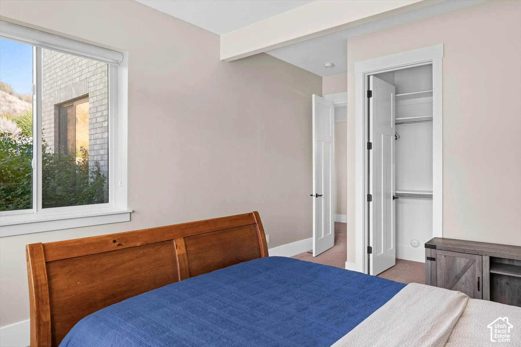 Spacious room featuring a single window, built-in closet with shelves and hanging rod, and light-colored walls