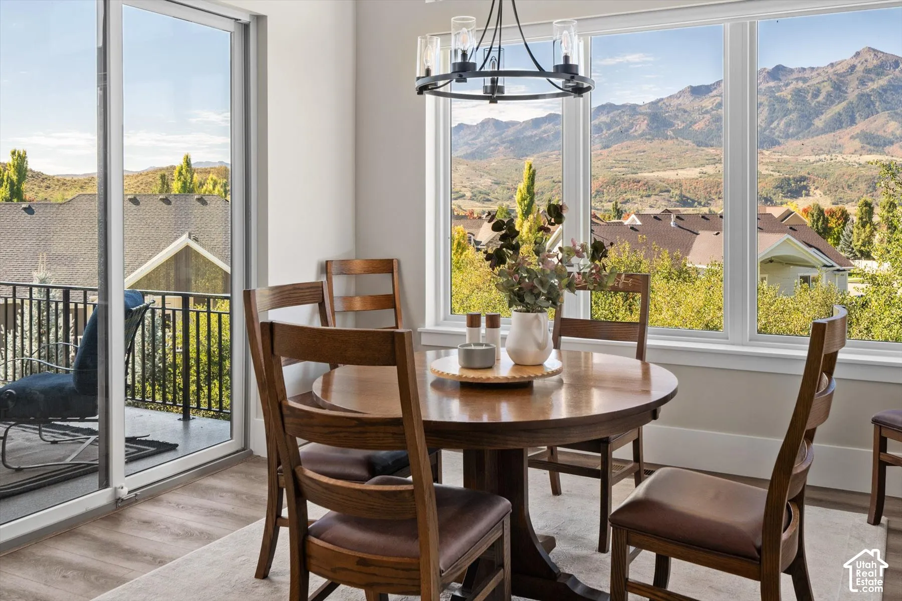 Dining area featuring a contemporary chandelier, wood-finish flooring, a full-lite sliding glass door, and expansive windows