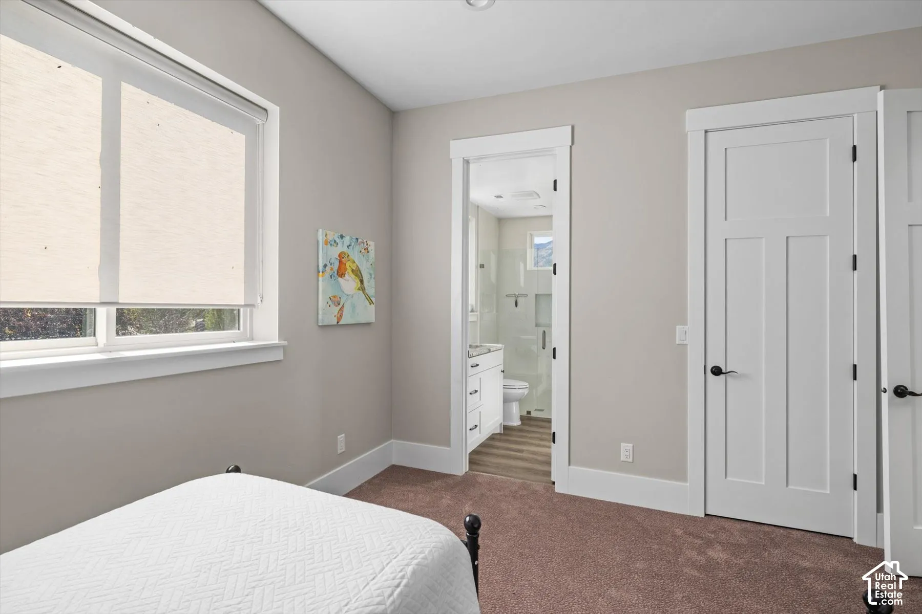 White trim windows, neutral wall tones, broadloom carpeting, white panel doors, and a bathroom with a white vanity