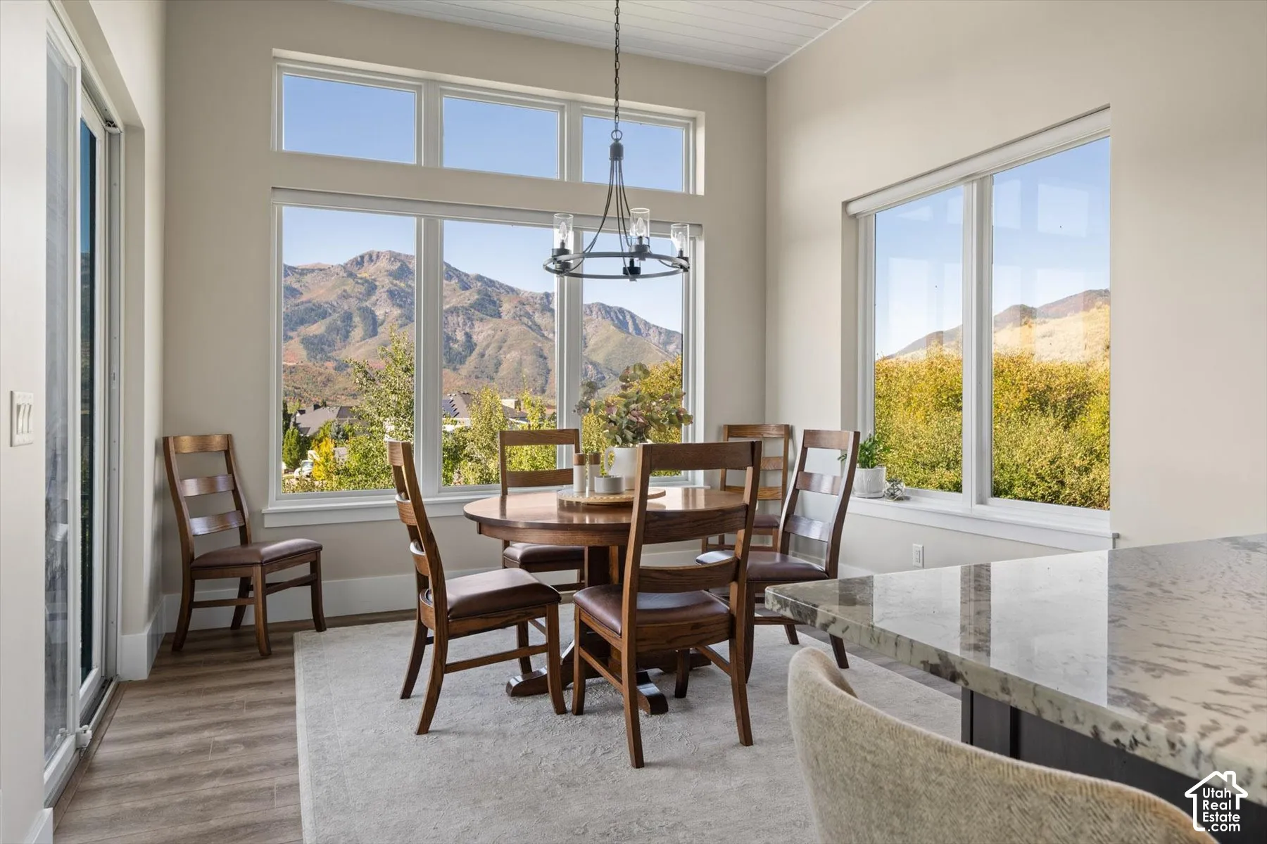 Vaulted ceilings, wood-finish flooring, mountain backdrop, and abundant natural light from expansive windows