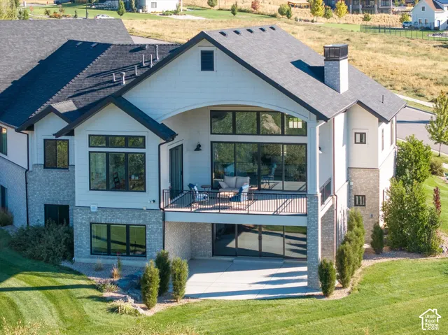 Multi-story exterior with a covered balcony and an additional lower-level patio