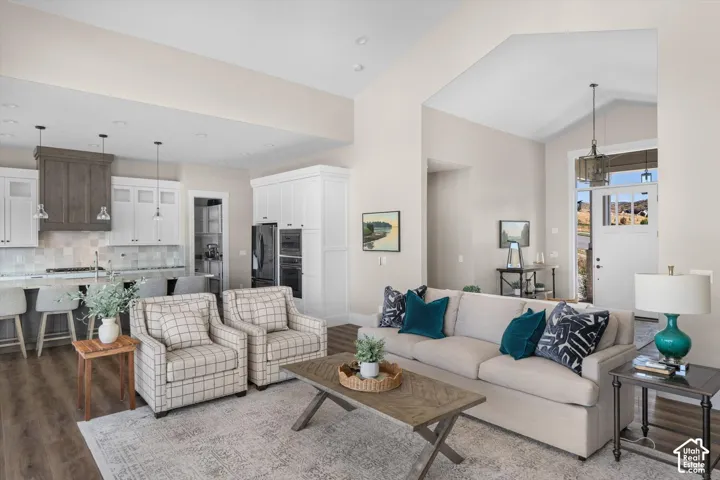 Open-concept living space featuring wood-finish flooring and vaulted ceilings