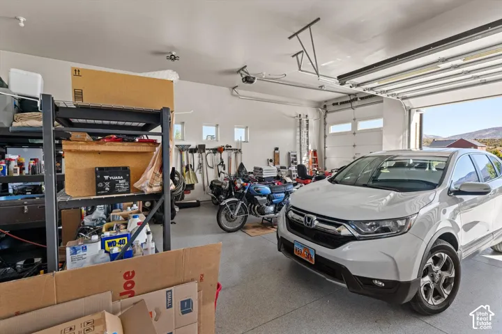 Attached garage with an epoxy-coated floor, multiple windows, and overhead lighting