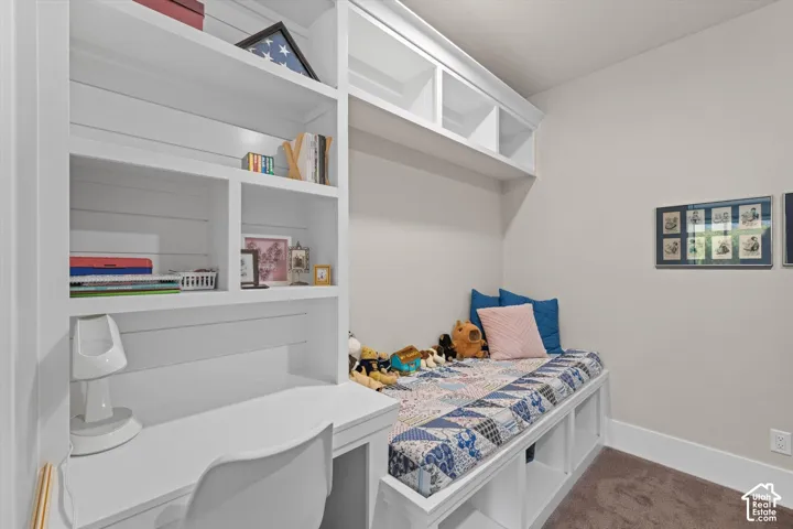 Built-in desk and shelving unit with an integrated daybed, featuring storage cubbies below