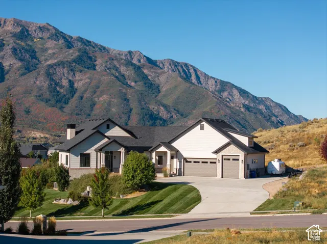 Two-car garage with overhead doors, expansive concrete driveway, and a stone facade