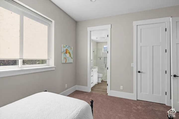 White trim windows, neutral wall tones, broadloom carpeting, white panel doors, and a bathroom with a white vanity