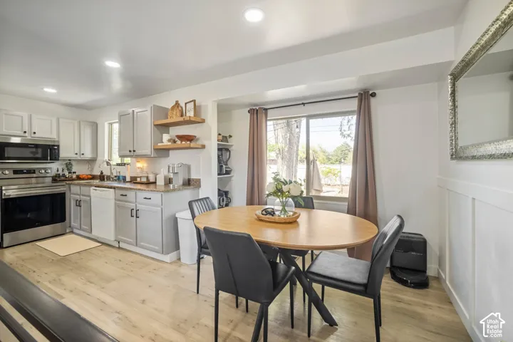 Kitchen and dining area featuring light wood-finish flooring, recessed lighting, and a kitchen with stainless steel appliances