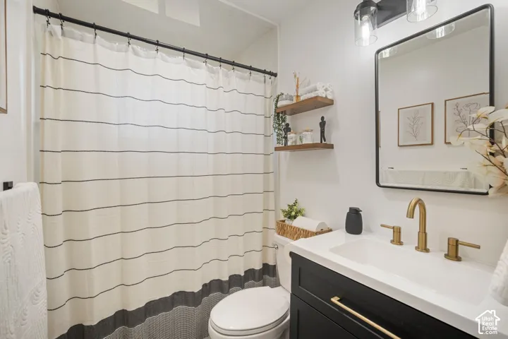 White vanity with integrated sink, gold-finish faucet, and coordinating hardware
