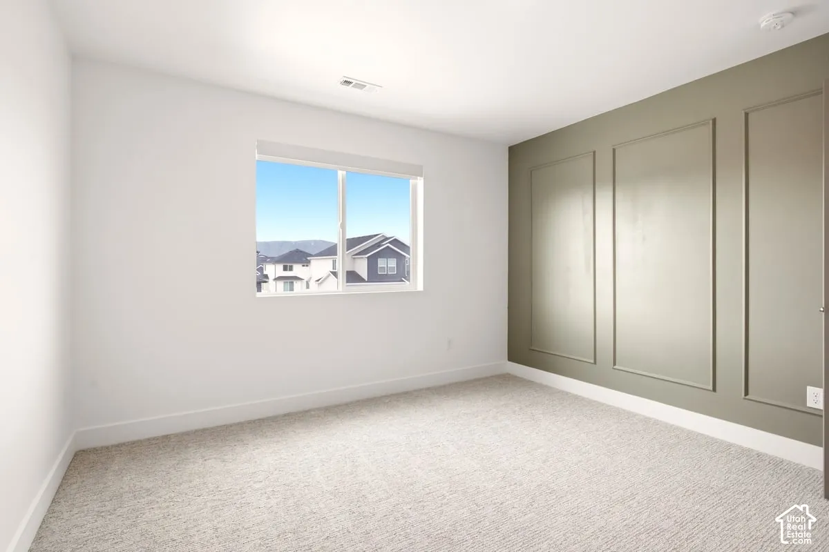 Interior room featuring wall molding, neutral carpeting, and a sliding window
