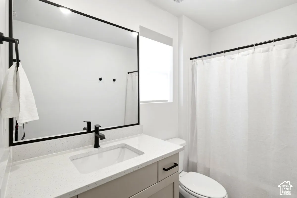 Modern bathroom with a light-colored vanity, white rectangular sink, and matte black faucet