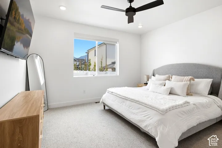 Recessed lighting, a black ceiling fan, and a large window illuminate this space