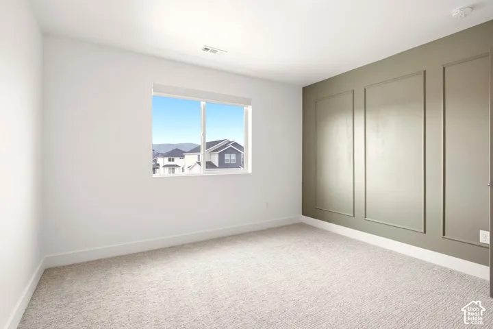 Interior room featuring wall molding, neutral carpeting, and a sliding window