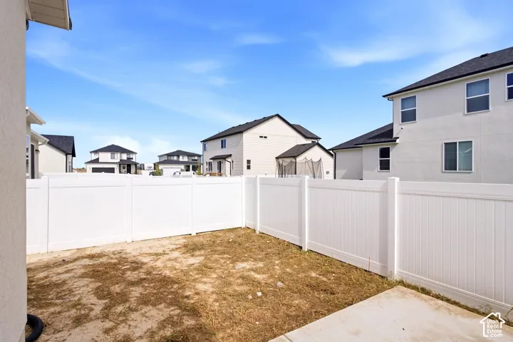 Private backyard with white vinyl fencing and a concrete patio section