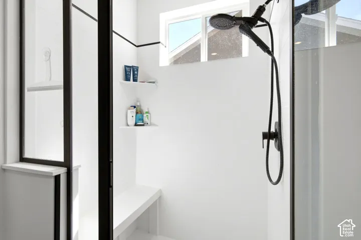 Shower with a built-in bench, integrated shelving, and a matte black shower fixture