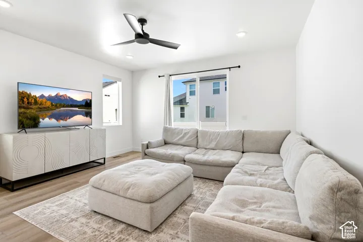 Recessed lighting, wood-finish flooring, white walls, and a modern ceiling fan